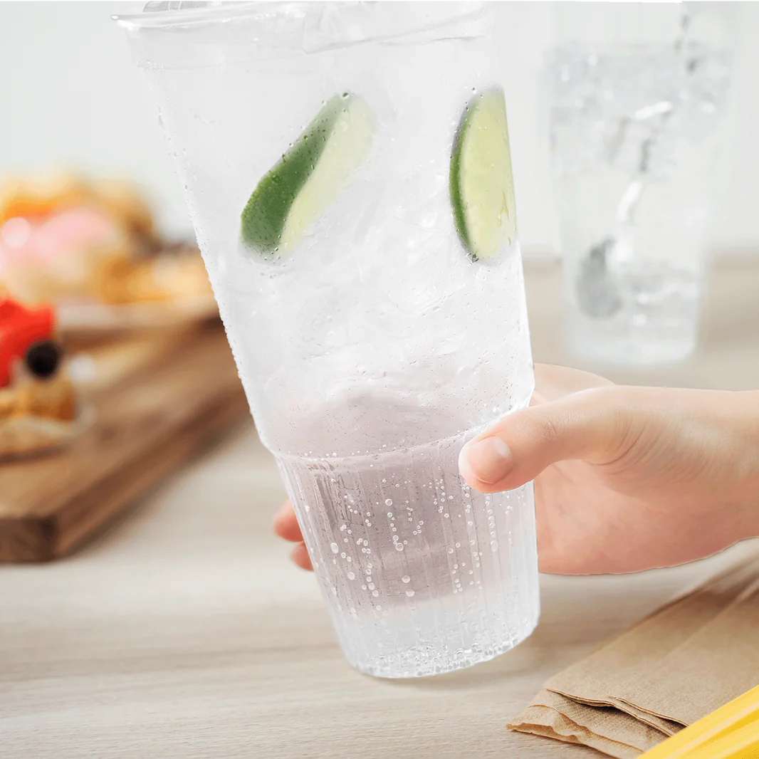 Server’s hand grabbing a 42 oz clear PP cold drink cup – large recyclable cup with 115 mm rim ready for customer