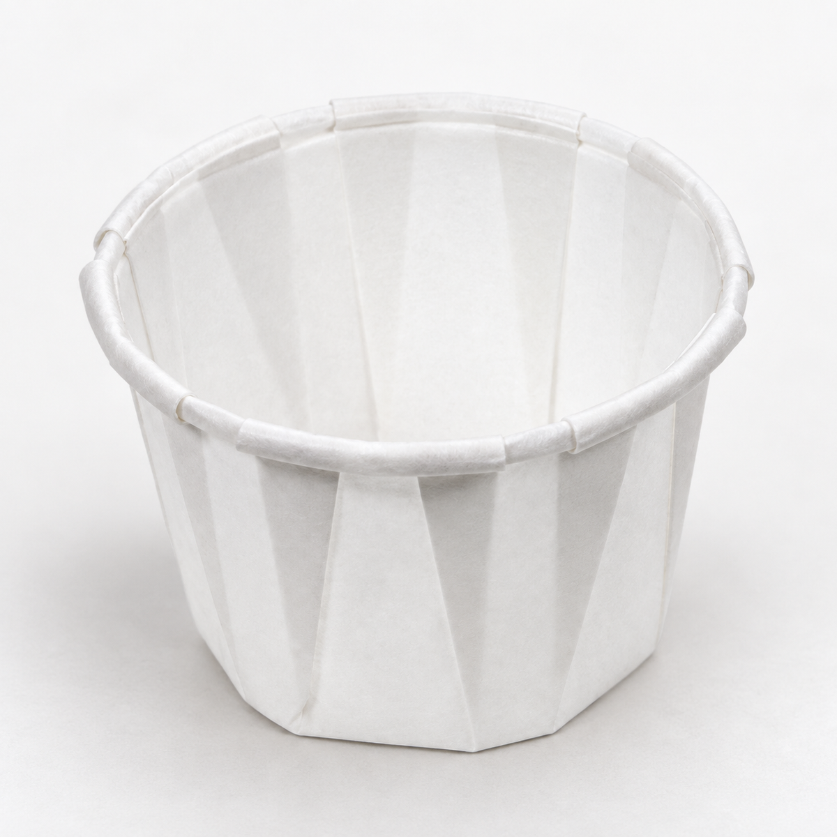 Genpak F100 white pleated paper portion cup showing the rolled rim and open interior