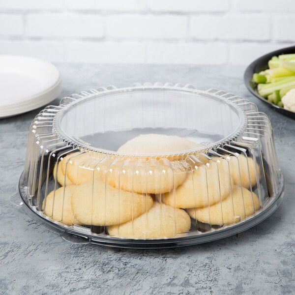 WNA 12 inch clear dome lid on a black tray with cookies; tray and food sold separately